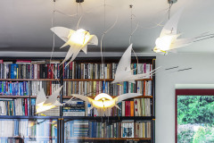 Lastovičky poletujúce nad jedálenským stolom pútajú pozornosť nielen na seba, ale aj na rodinný poklad v pozadí -  knižnicu po dedkovi, ktorá tvorí stredobod interiéru