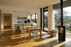 Pre základnú farebnosť domu bola zvolená čierna a biela, ktoré zjemňujú odtiene dreva a zemité a pastelové tóny nábytku a doplnkov