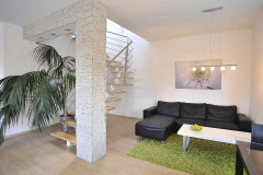 Manželia si vybrali otvorené oceľovo-drevené schodisko. Jeho vzdušná konštrukcia opticky zväčšuje priestor