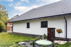 Nízky skladaný sokel, biela fasáda a tmavá strešná krytina Tondach v čiernej farbe sú odkazom na podhorské domy 19. storočia, vo vnútri domu však vládne storočie dvadsiate prvé