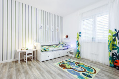 Detská izba poskytuje dostatočný priestor na detské hry, okrem skrine slúži na ukladanie priestor v spodnej časti postele. V detskej izbe nás zaujala aj zavesená sedačka v podobe opice