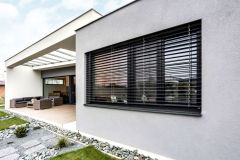 Terasu so sedacou súpravou a stolom kryje presklená plochá strecha, neuberá tak denné svetlo obývačke