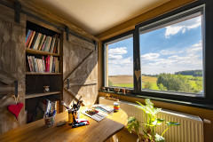 Jednou nevšednou požiadavkou zadávateľov bolo vybudovanie ateliéru. Majiteľka si priala vytvoriť v dome priestor, kde by mohla nerušene pracovať na svojich dielach. Výtvarné štúdio nakoniec získalo svoje miesto na prvom poschodí, odkiaľ je nádherný výhľad do okolia