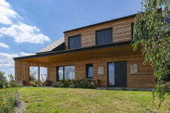 Fasáda má vetraný obklad zo smrekovcového dreva, ktoré časom získa prirodzenú patinu. Jeho sfarbenie kontrastuje s antracitovými okennými rámami, žalúziami a čiernu škridlovou krytinou