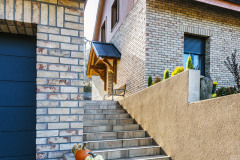 Dom je zasadený do príkreho svahu, čo sa neobišlo bez vonkajšieho schodiska začínajúceho sa pri príjazdovej ceste