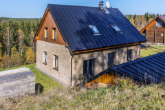 Dom je zasadený do nádhernej krajiny, v pravom rohu obrázku vidíte strechu záhradného altánku. Strechy sú pokryté plechovými šablónami – krytinou vhodnou v horách