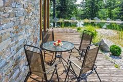 Fasáda domu je z dosiek sibírskeho smrekovca doplnených o pásy kvarcitového kameňa. Drevená terasa prepája obývaciu izba s hlavným vchodom a spálňou