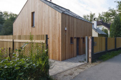 Od príjazdovej komunikácie zo severu delí domček uzavretý plot. Jeho štýl zodpovedá celkovému vzhľadu stavby