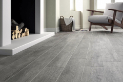 Dlažba Rustica tak dizajnom, ako aj formátom (19,5 × 84 cm) vytvára dojem masívnej drevenej dlážky. V ponuke sú tri odtiene, na snímke „Dymová“ Rustica Gris (JiKA)