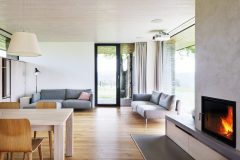 Drevený nábytok a biely interiér v prvom podlaží tvoria negatív k drevenému interiéru a bielemu nábytku podkrovia