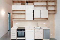 Box z preglejky obsahuje okrem kuchyne šatňu, technickú miestnosš, schodisko a pracovňu v podkroví s malou knižnicou. Pri dolnej spálni je k nemu pripojená kúpeľňa so sprchovacím kútom a samostatné WC