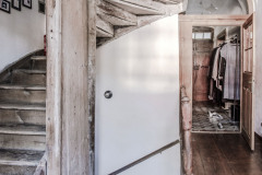 Pod starými drevenými schodmi, ktoré vyniknú vďaka výraznej patine, sa skrývajú vstupné dvierka na schodisko do prízemia